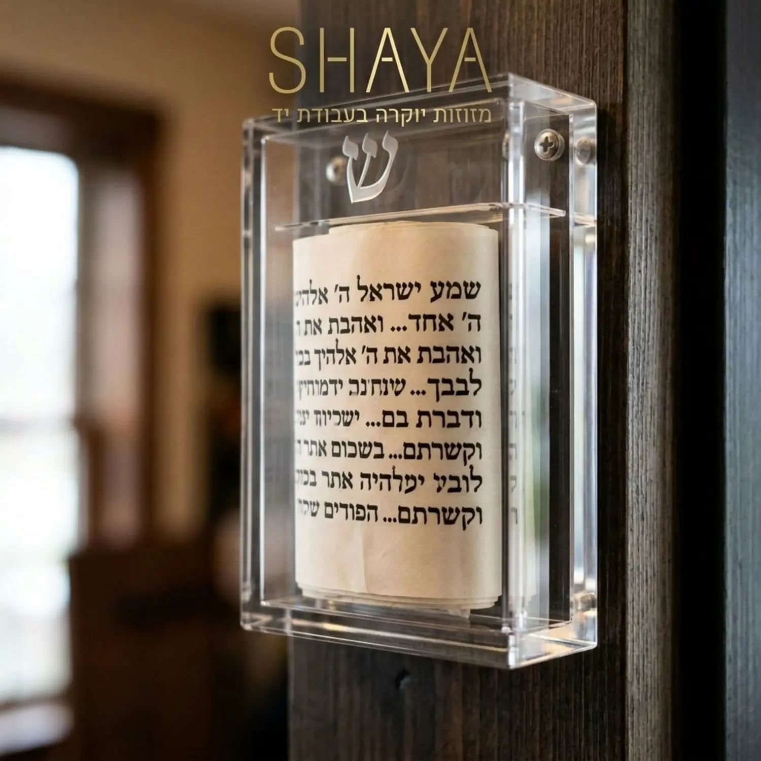תקריב של בית מזוזה עשוי זכוכית אקרילית שקופה, דרכו ניתן לראות קלף מזוזה כתוב בכתב סת
